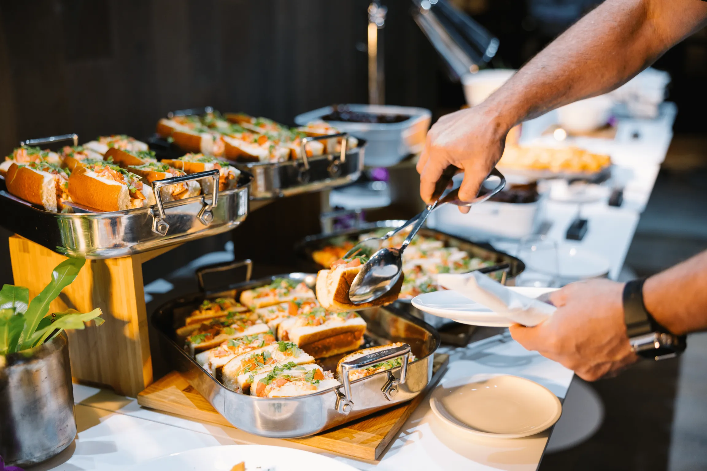 A person serving food on their dish from the catering bar on their corporate event