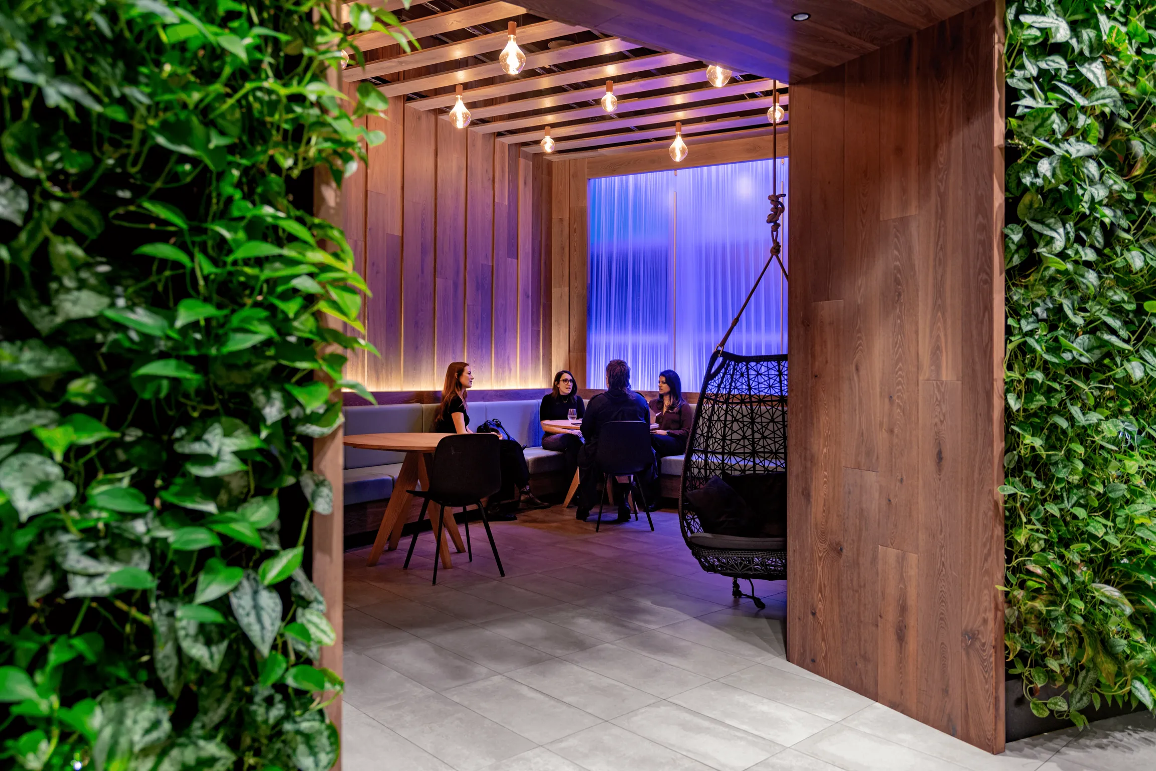 People gathered in 151 West 42nd's amenity space, sitting at tables and engaging in conversations.